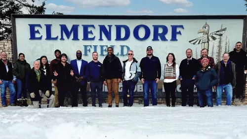 The Pond-CDM Smith team standing in front of the Elmendorf field sign