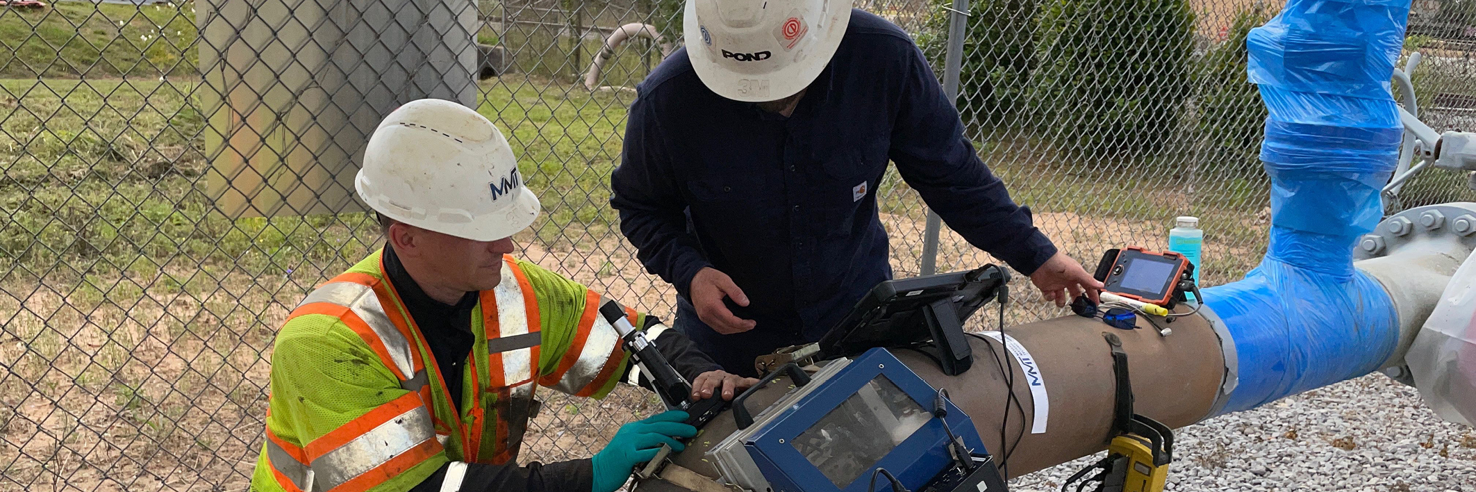 Two engineers inspecting a pipeline.