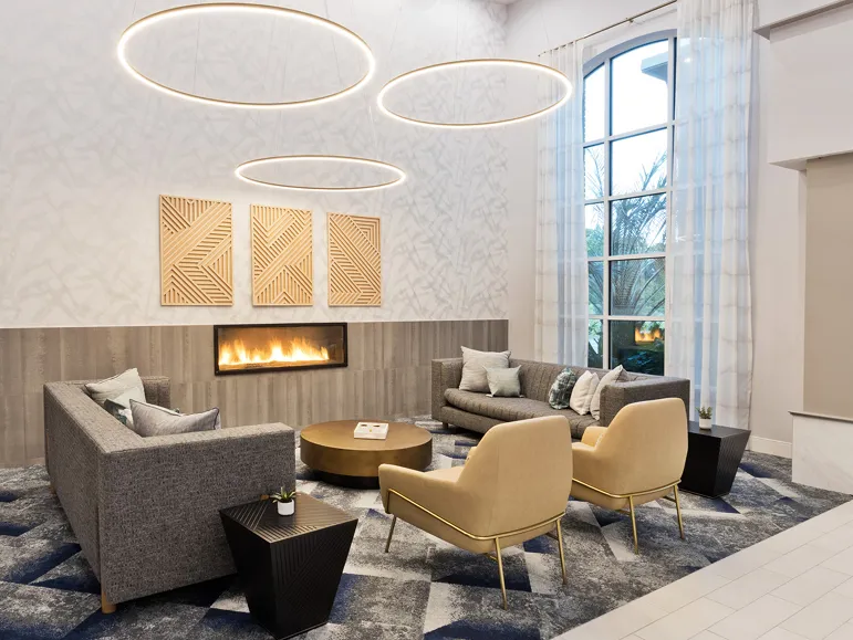 Seating area with a couch and chairs inside Hilton's Hampton Inn