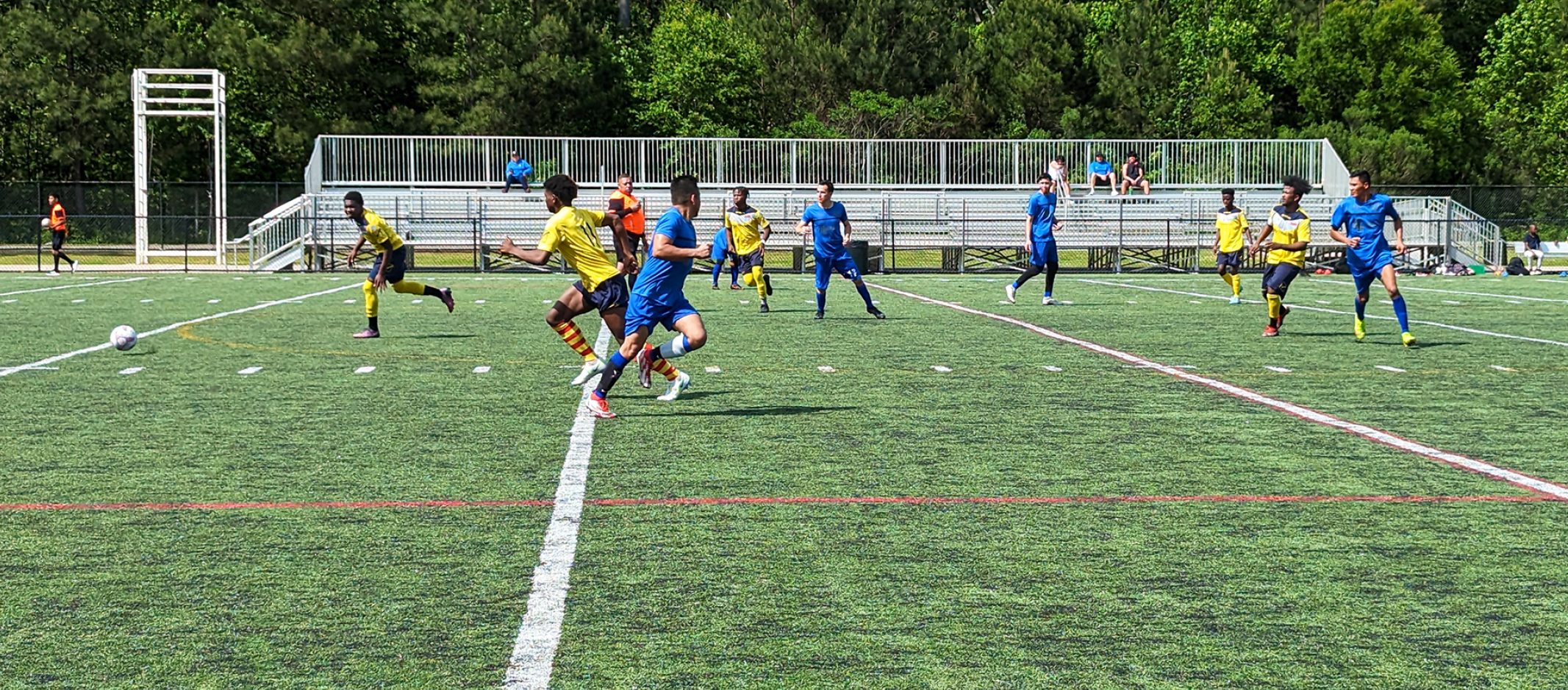 Kids playing soccer on a turf field.